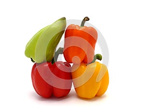 Four ripe sweet peppers on a light background. Red, yellow, green and orange.