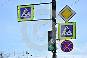 Four road signs and green traffic lightagainst blue background, Saint-Petersburg, Russia