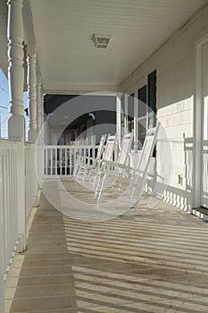 Four Rocking Chairs On A Porch At Sunrise