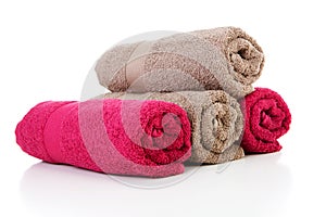 Four rolled colorful towels in red and brown