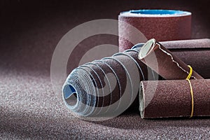 Four rolls of sanpaper on abrasive background