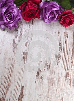 Four roses of different colors on wooden background