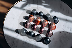 Four rows of coffee capsules with shadow on table