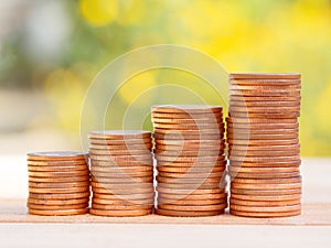 Four rows of rising growth golden stack coins with green nature background. Growing and saving money concept