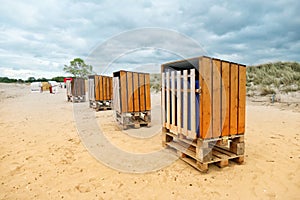 Four rustic beach chairs, from wooden boards and Euro pallets, stands in a row on the Baltic Sea beach in Schleswig-Holstein, Germ