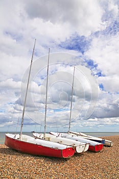 Four sailboats on a pebble beach