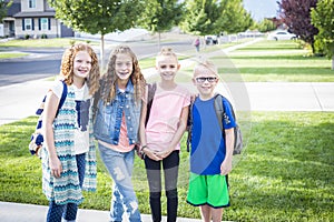 Four school kids heading off to school in the morning