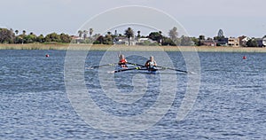 Four senior caucasian men and women in rowing boat raising hands and cheering