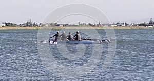 Four senior caucasian men and women rowing boat on a river