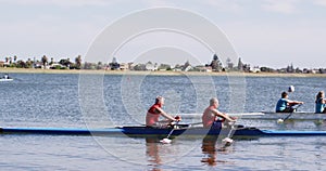 Four senior caucasian men and women rowing boat on a river