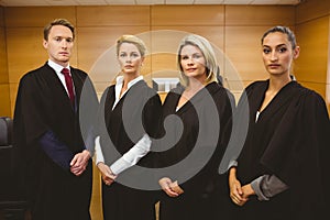 Four serious judges standing while wearing robes