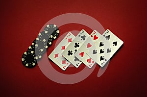 Four sevens in a poker game is a winning combination of four of a kind or quads on a red table in a club photo