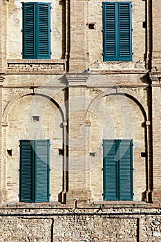 Four shuttered windows in a geometric brick wall