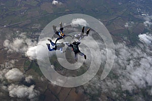 Four skydivers building a formation