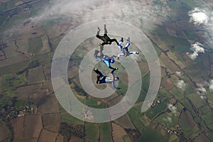 Four skydivers building a formation