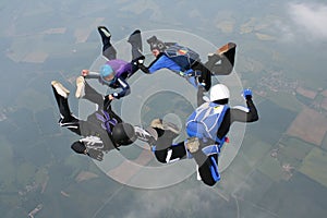 Four skydivers in freefall forming a circle