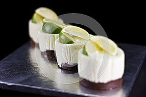 Four small cakes decorated with lime wedges