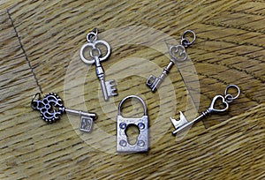 Four small decorative skeleton keys around a closed old fashioned lock