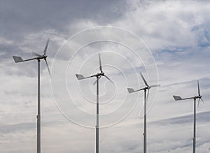 Four small wind turbines in the background of clouds. Environmentally friendly source of energy.