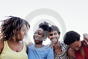 Four smiling mixed race friends standing and looking down at camera