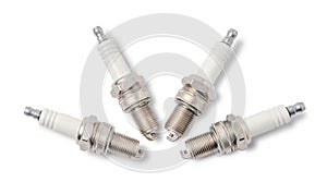 Four spark plugs on white. Top view.