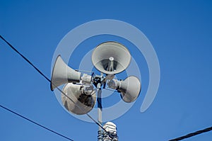 four speakers on the top of a pole