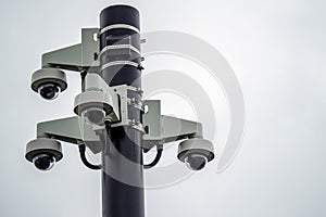 Four spherical CCTV cameras fixed on a black metal pole. Security and safety concept