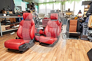 Four sport seats with red leather trim, located on the floor in the workshop for repair and tuning