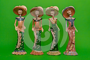 Four statuettes of Calaveras de la Catrina laughing at death