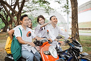 Four students riding motorbikes on the road