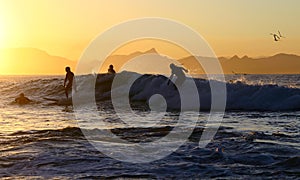 Four surfers on one wave