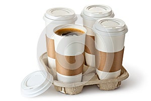 Four take-out coffee in holder. One cup is opened.