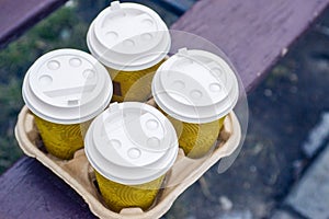 Four take-out coffee in holder. Take coffee to work for the entire office. Coffee time concept