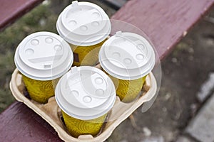 Four take-out coffee in holder. Take coffee to work for the entire office. Coffee time concept