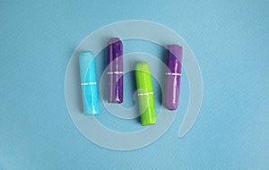 Four tampons on turquoise background, flat lay