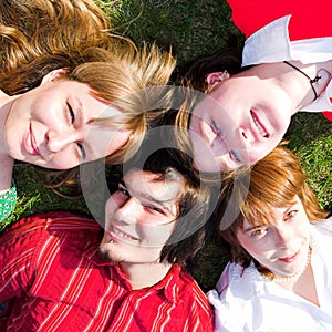 Four teenager lay on grass