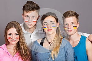 Four teenagers with flags drawn on the faces