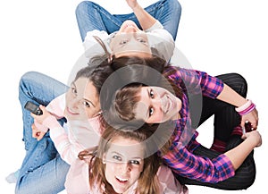 Four teenagers sitting on white with cellphones