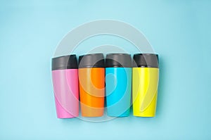 Four thermo mugs on the blue background with copy space