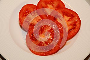 FOUR TOMATOES SLICIES IN PLATE IN COPENHAGEN