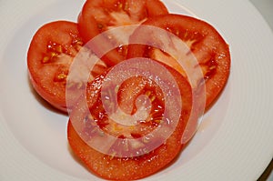 FOUR TOMATOES SLICIES IN PLATE IN COPENHAGEN