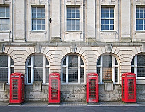 Four traditional british red phone boxes outside an old post office building in blackpool england