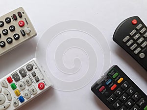 Four tv remotes in white background
