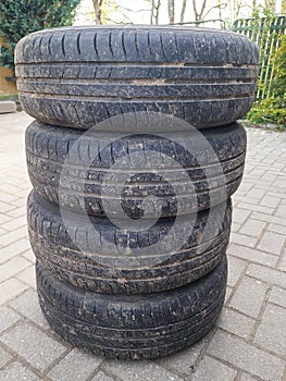 Four used car summer tires with wheels stacked