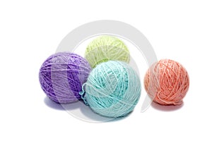 Four varicolored balls of yarn on white background