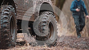 a four-wheel drive all-terrain vehicle drives through the forest through the mud. a passable SUV with large wheels and