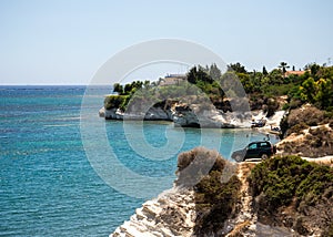 A four wheel drive car dangerously parked next to steep cliff at Governor`s beach, Cyprus