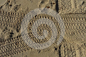 Four wheel drive tracks in sand textured background