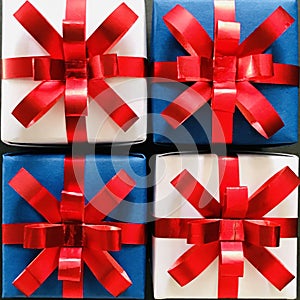 Four white and blue Christmas gift boxes tied with red ribbons.