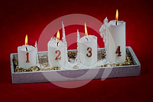 Four white burning candles welcoming fourth advent.